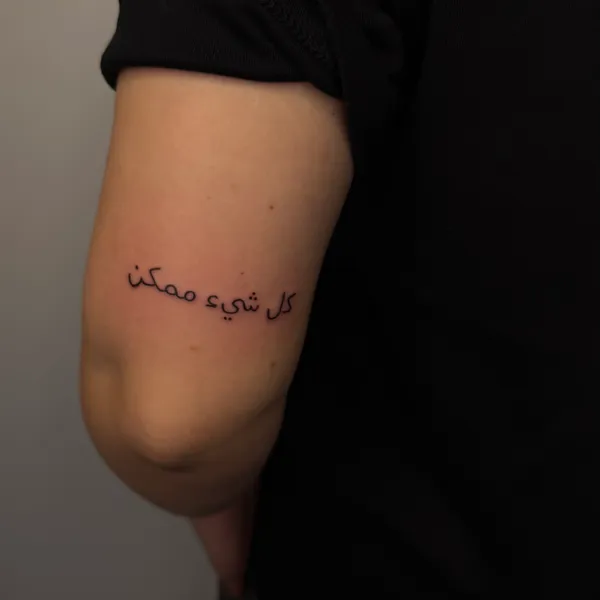 Minimalistinė užrašo tatuiruotė su plonu šriftu