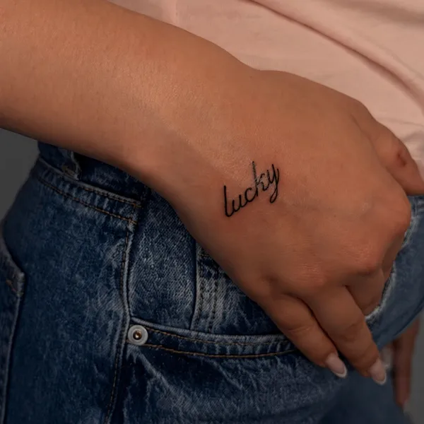 Minimalistinė 'lucky' užrašo tatuiruotė